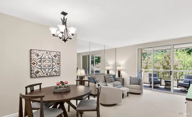 a view of a dining room with furniture a chandelier and a window