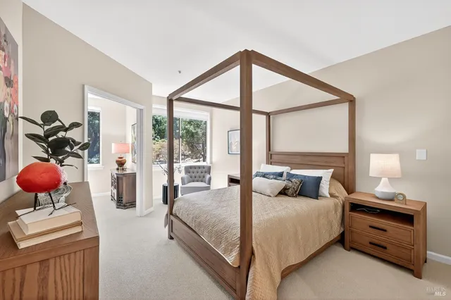 a bedroom with a bed and large windows