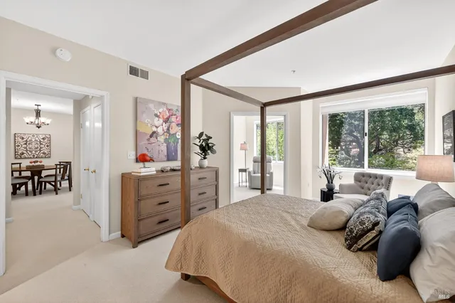 a bedroom with a bed and large windows