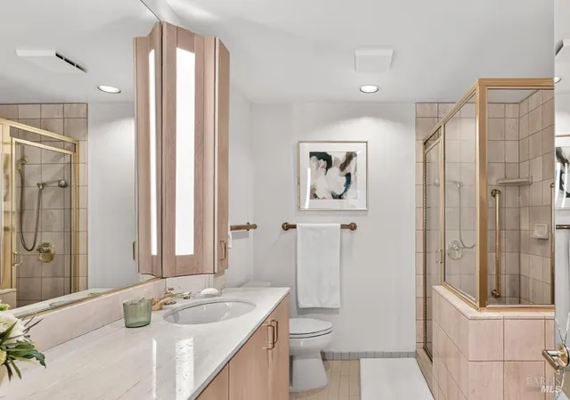 a bathroom with a granite countertop sink toilet and shower