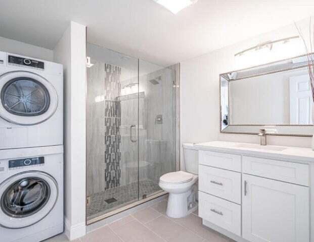 9284 Vista Del Lago, Unit 34F Boca Raton, FL 33428 - Photo 6 of 15 a bathroom with a toilet sink a mirror a shower and vanity