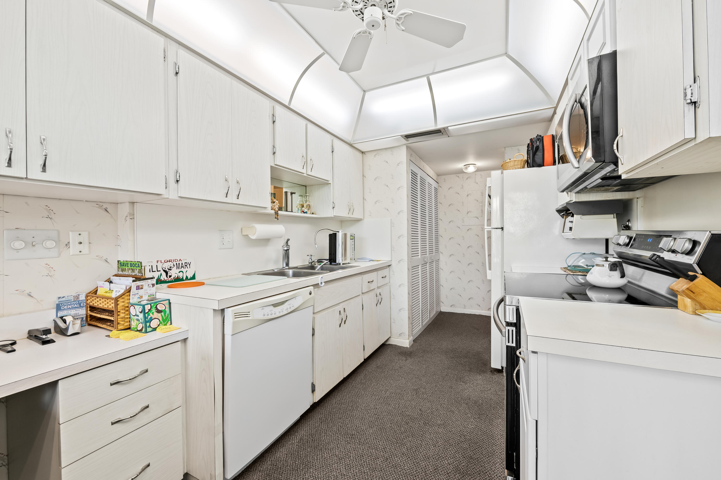 799 Jeffery Street, Unit 4050 Boca Raton, FL 33487 - Photo 7 of 39 a kitchen with a sink dishwasher and white cabinets