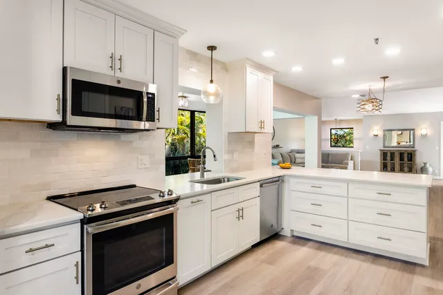 a kitchen with counter space dining table and stainless steel appliances