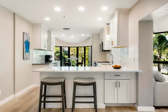 a kitchen with a table chairs stove and wooden floor