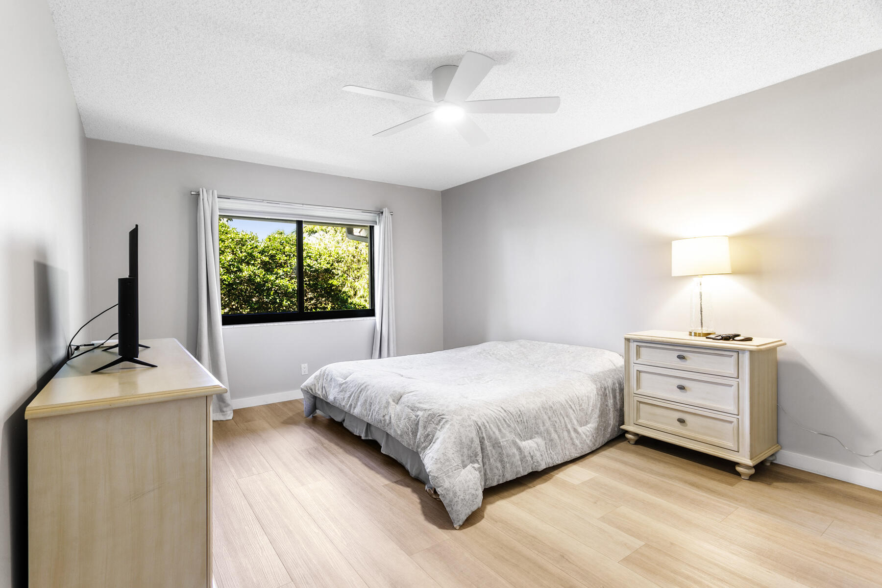 17137 Waterbend Drive, Unit 201 Jupiter, FL 33477 - Photo 19 of 43 a bedroom with a bed and a flat tv screen on a dresser