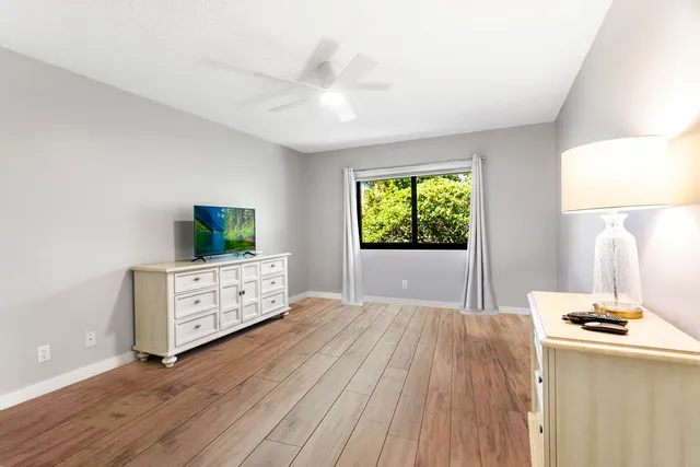 a bedroom with a bed and a flat tv screen on a dresser