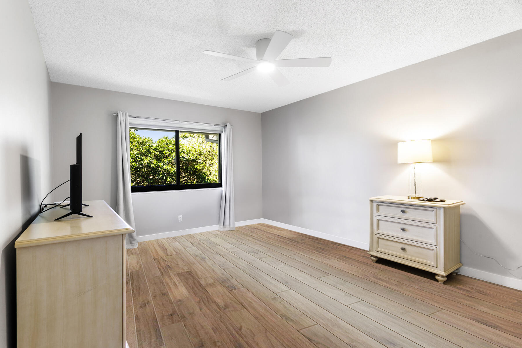 17137 Waterbend Drive, Unit 201 Jupiter, FL 33477 - Photo 23 of 43 a bedroom with a bed and a flat tv screen on a dresser