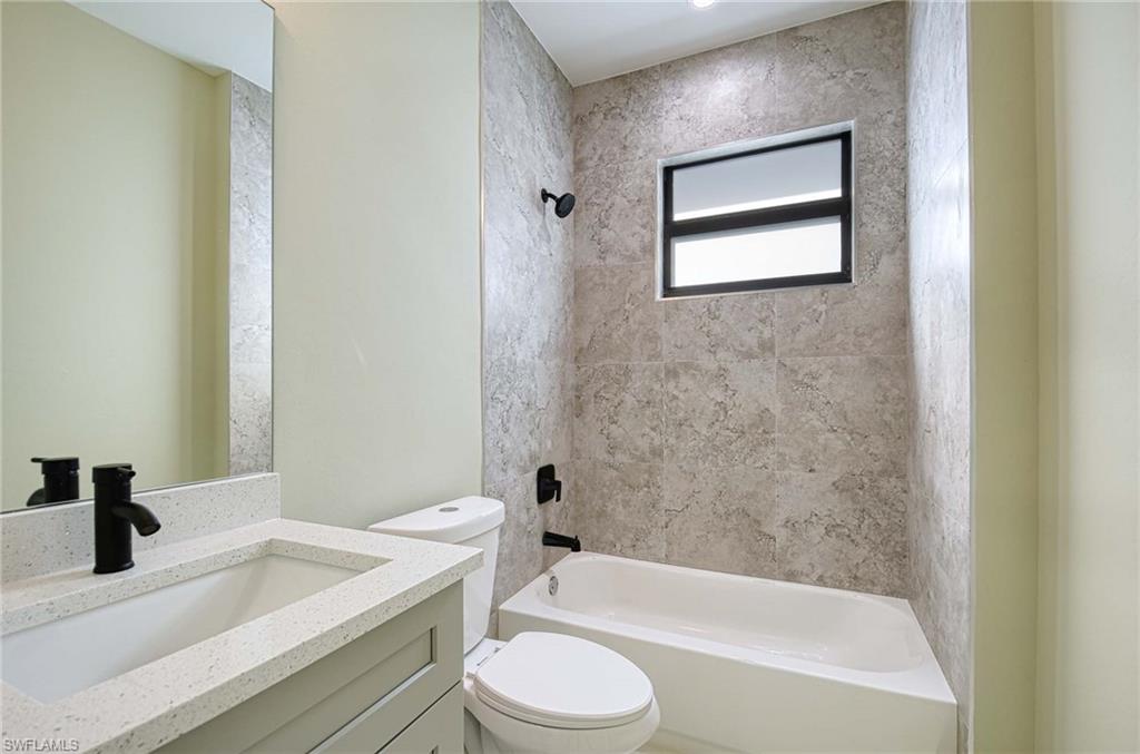219 33rd Avenue Northwest Naples, FL 34120 - Photo 33 of 41 a bathroom with a bathtub shower sink vanity mirror and toilet