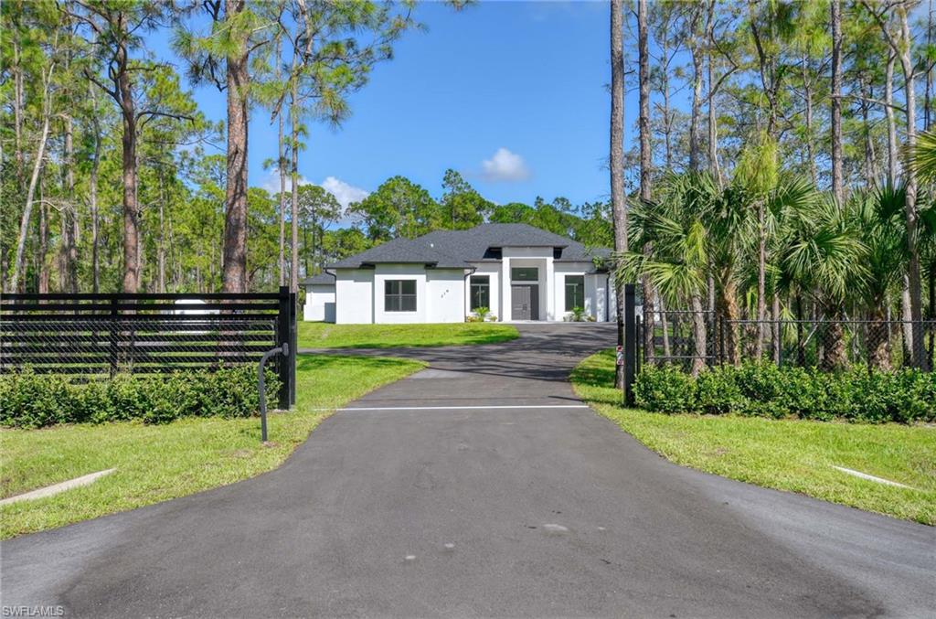 219 33rd Avenue Northwest Naples, FL 34120 - Photo 34 of 41 a front view of a house with a yard and potted plants