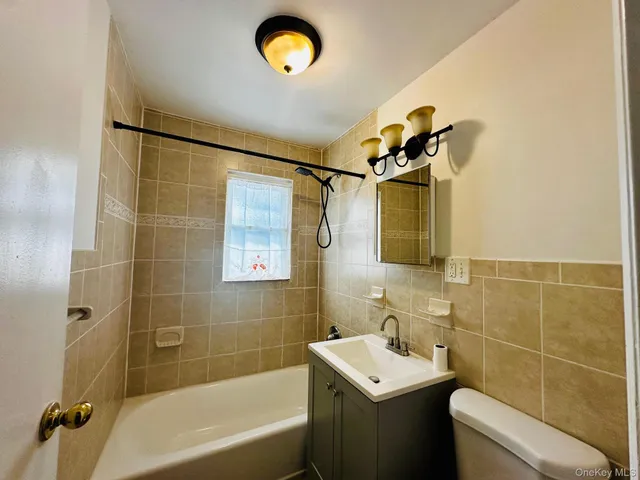 a bathroom with a sink mirror toilet and bathtub