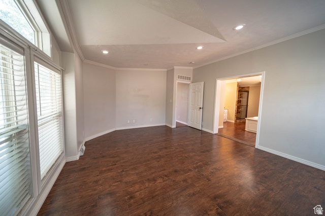 1407 North 1250th Street West Helper, UT 84526 - Photo 17 of 27 Large Master bedroom featuring crown molding, dark wood-type flooring, recessed lighting, and vaulted ceiling