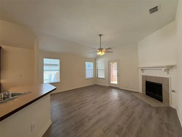an empty room with windows and fireplace