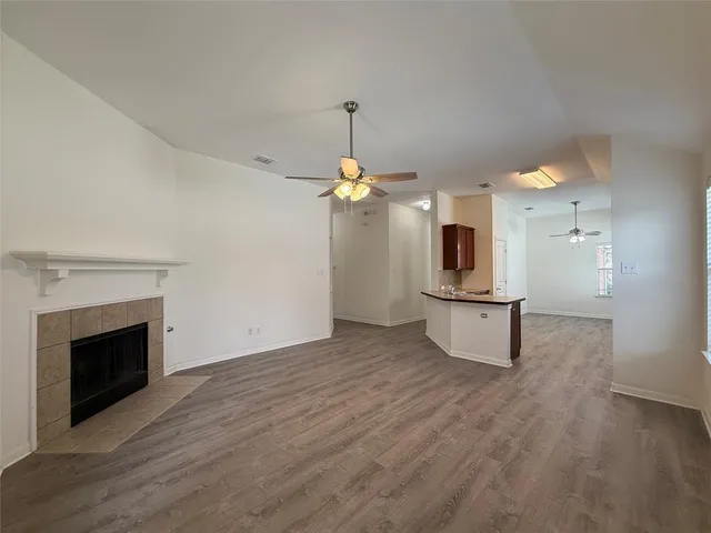 a view of a kitchen with a sink a fireplace and wooden floor