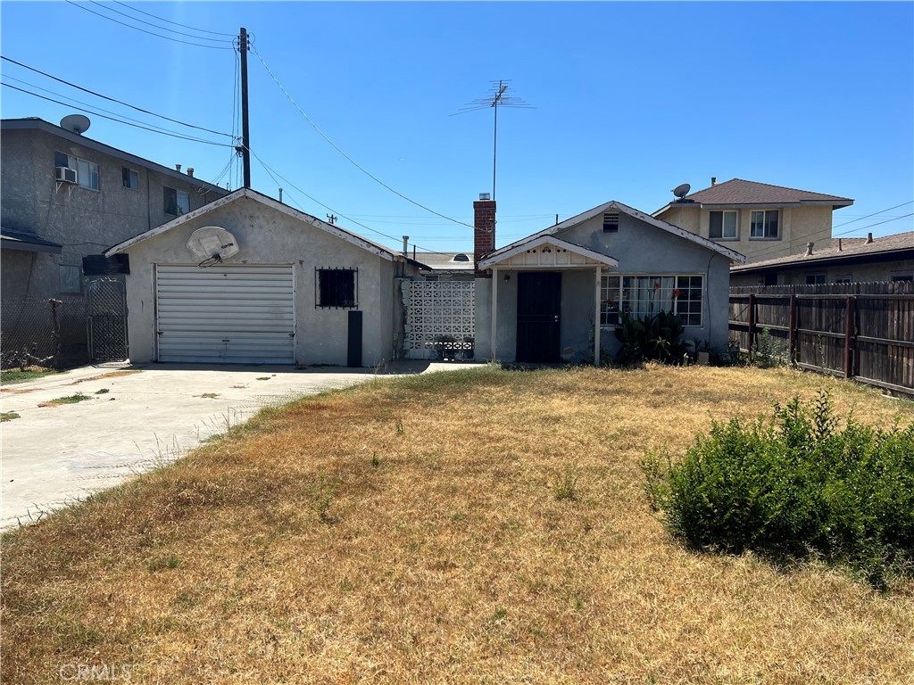 6942 Watcher Street Commerce, CA 90040 - Photo 1 of 14 a front view of a house with a yard