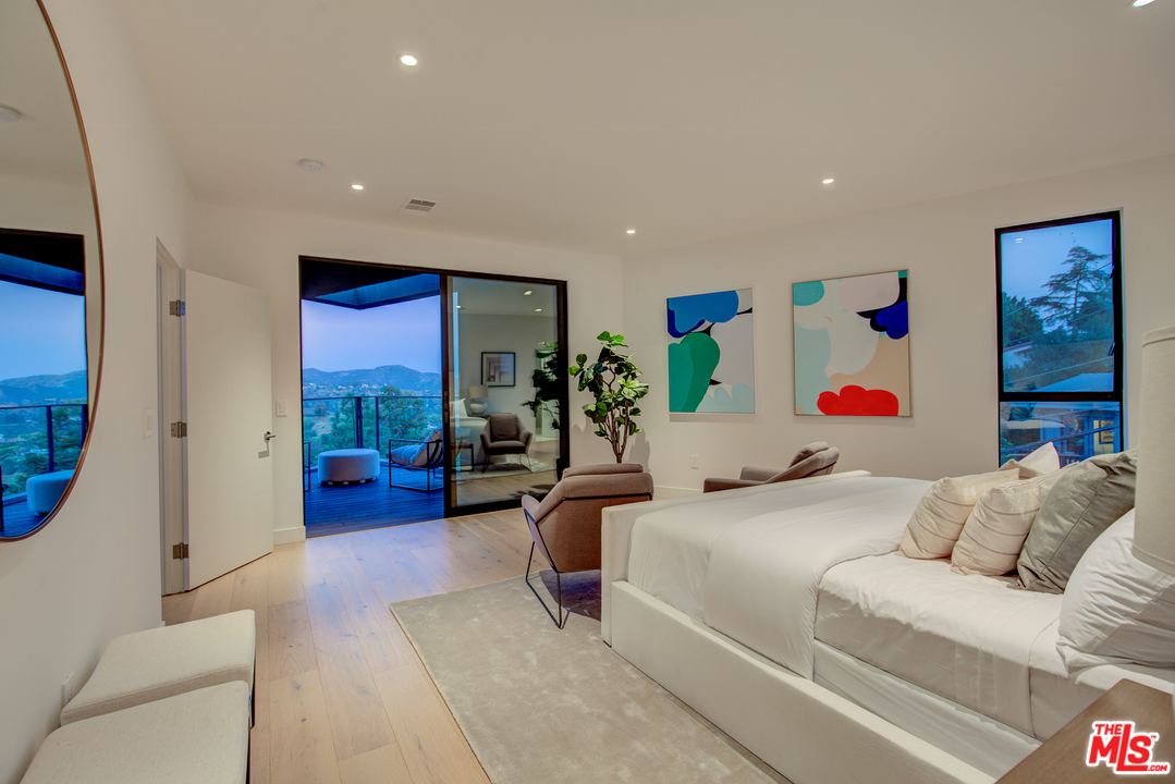 6876 Pacific View Drive Los Angeles, CA 90068 - Photo 17 of 31 a bedroom with furniture and a large window