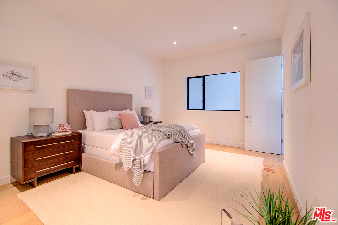 6876 Pacific View Drive Los Angeles, CA 90068 - Photo 22 of 31 a bedroom with a bed and a chandelier