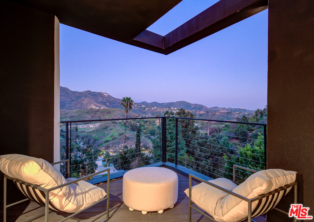 6876 Pacific View Drive Los Angeles, CA 90068 - Photo 31 of 31 a view of a balcony with a table and chairs