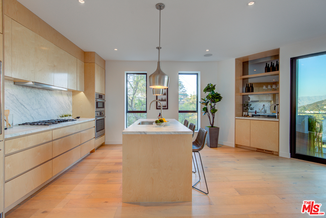 6876 Pacific View Drive Los Angeles, CA 90068 - Photo 8 of 31 a kitchen with kitchen island a stove a sink a center island and windows