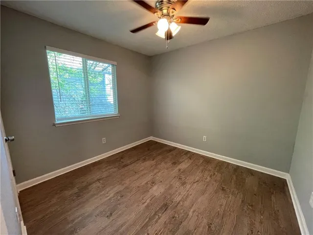 an empty room with a window and a fan