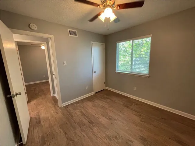 an empty room with wooden floor and window