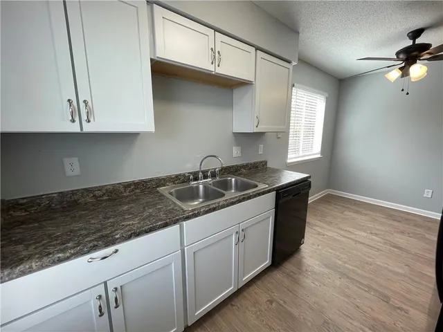 a kitchen with granite countertop white cabinets and white appliances