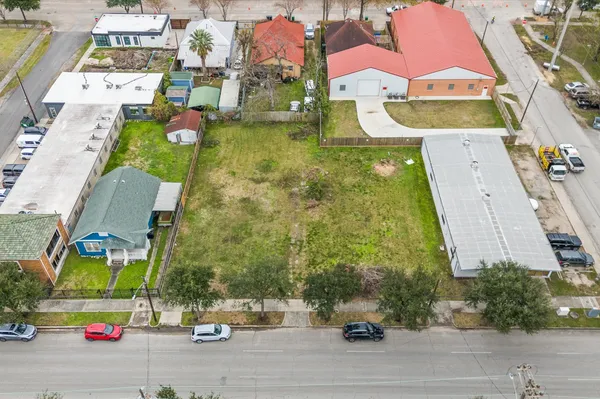 an aerial view of residential houses with outdoor space and parking