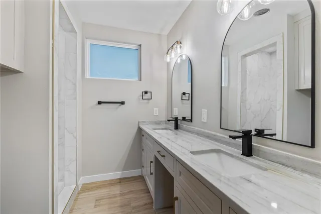 a bathroom with a granite countertop sink and a mirror