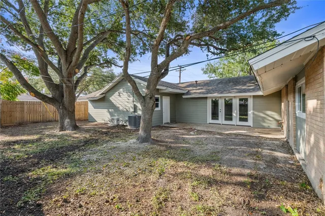 a view of a yard in front of a house with large tree