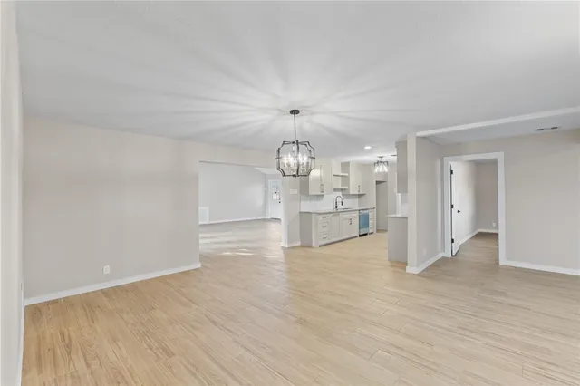 a view of a kitchen with wooden floor and a chandelier