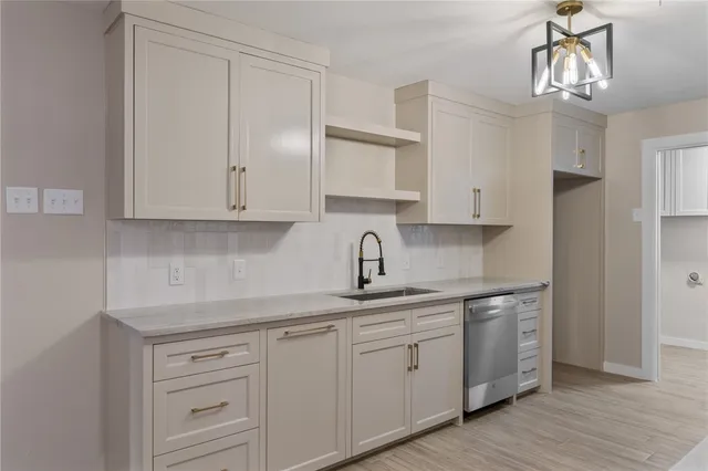 a kitchen with white cabinets and sink
