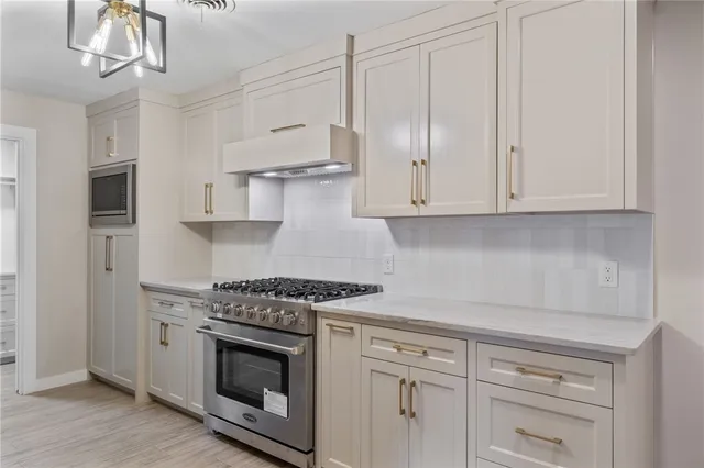 a kitchen with white cabinets and stainless steel appliances