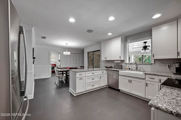 a kitchen with white cabinets and stainless steel appliances