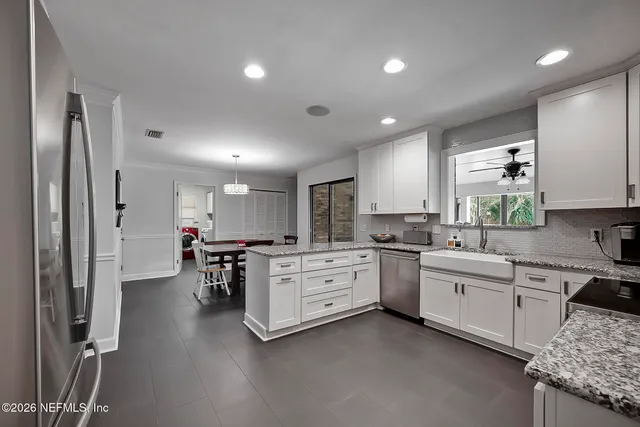 a kitchen with white cabinets and stainless steel appliances