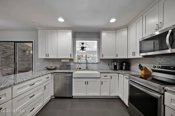 a kitchen with cabinets appliances a sink and a counter space