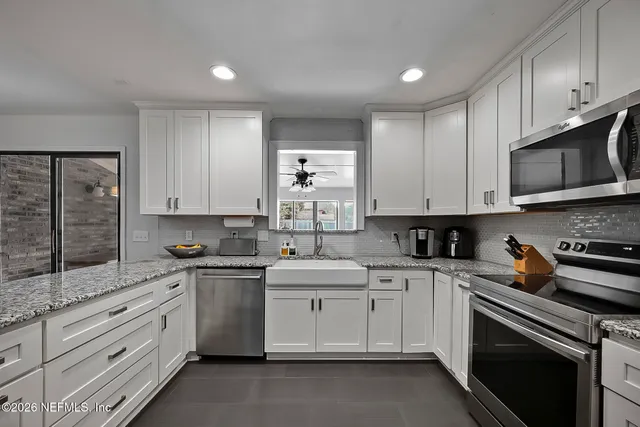 a kitchen with cabinets appliances a sink and a counter space