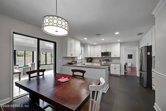 a open dining room with kitchen island furniture a chandelier and kitchen view