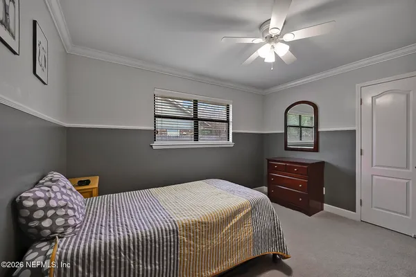 a bedroom with a bed and dresser with mirror