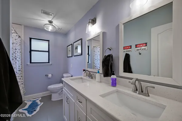 a bathroom with a double vanity sink mirror and toilet