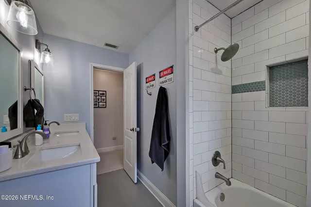 a bathroom with a sink vanity and shower