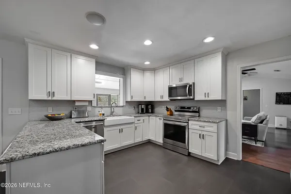 a kitchen with granite countertop stainless steel appliances and white cabinets