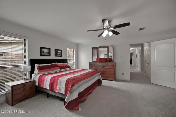 a spacious bedroom with a bed and a chandelier