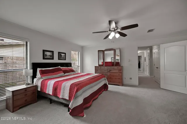a spacious bedroom with a bed and a chandelier