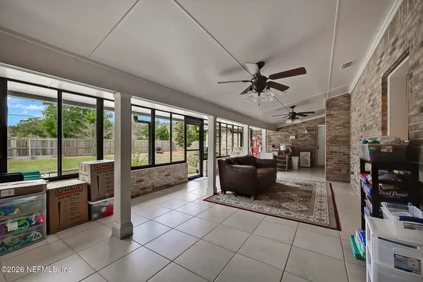 a living room with furniture a flat screen tv and a floor to ceiling window