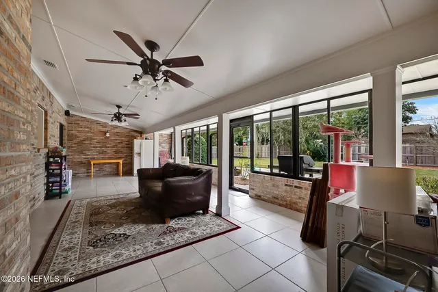 a living room with furniture and a floor to ceiling window