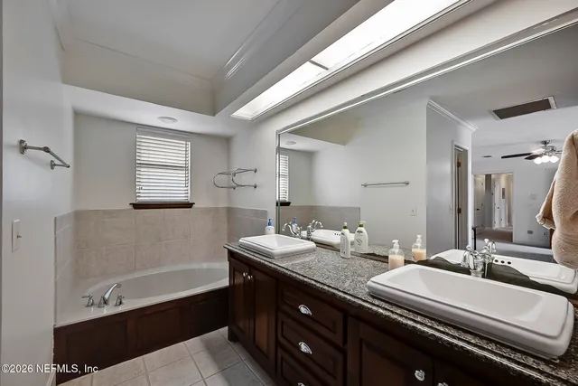 a bathroom with a double vanity sink a mirror and a bathtub