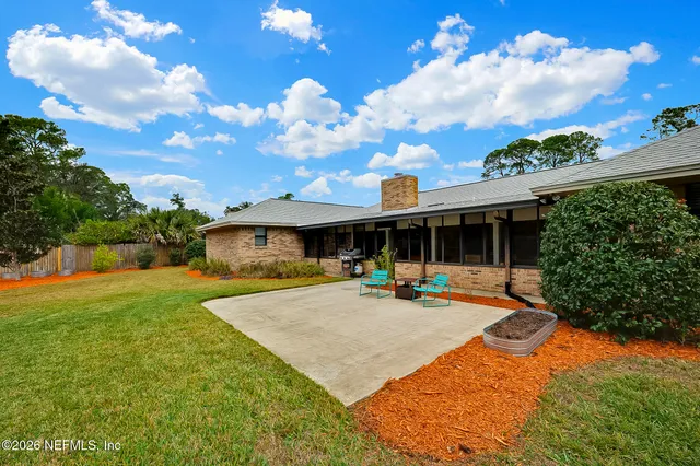 a view of a house with backyard and sitting area