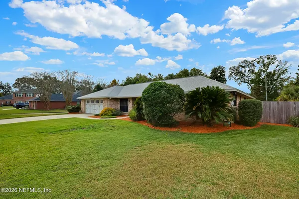 a view of a house with a big yard and potted plants