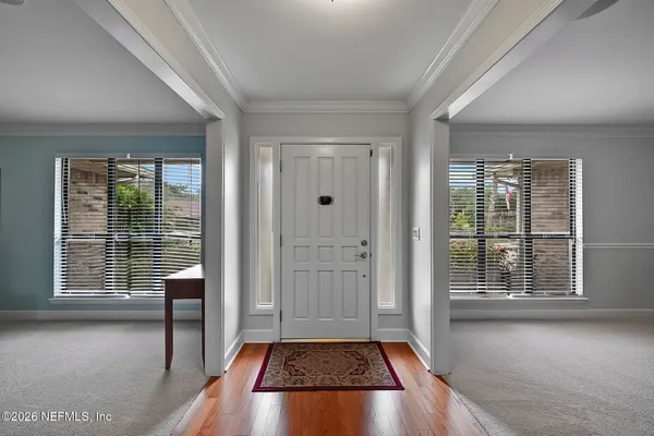 a view of a hallway with wooden floor and a living room