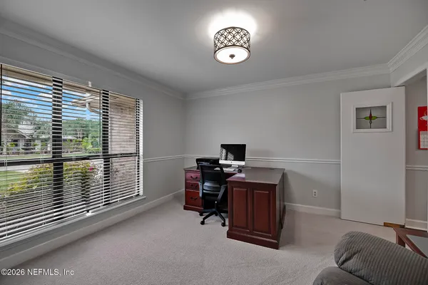 a view of a workspace with furniture and a window