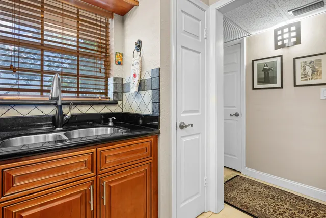 a bathroom with a granite countertop sink and a window